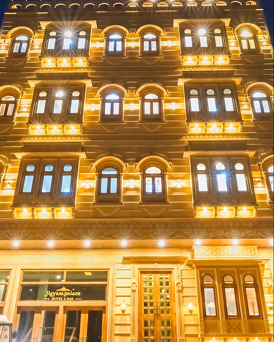 Illuminated sandstone facade of Hotel Jigyasa Palace with jharokha windows, Jaisalmer
