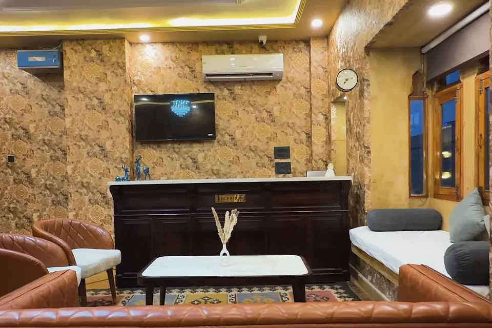 Reception lounge at Hotel Jigyasa Palace with leather sofas and sandstone walls